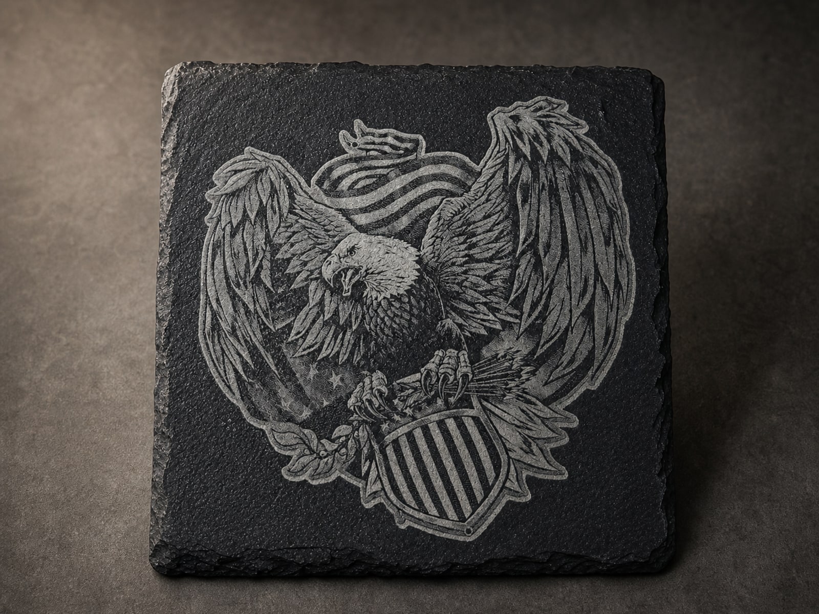Detailed bald eagle and shield engraving on a square black slate